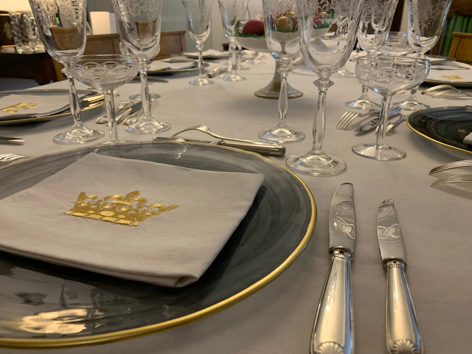 Couvert dressé : verres alignés, couverts en argent et assiette de présentation